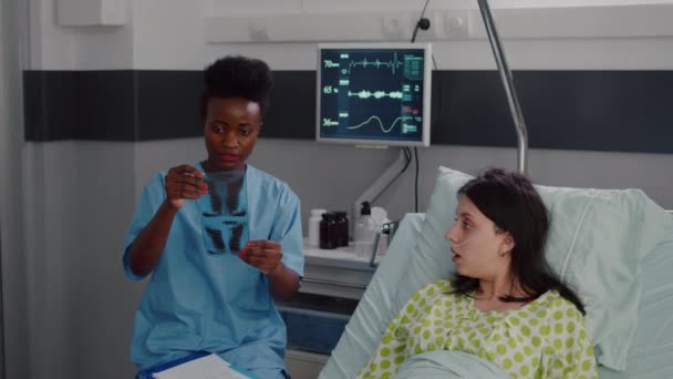 Primer plano de enfermera con piel negra analizando radiografía de huesos — Vídeos de Stock