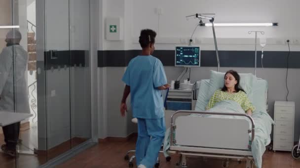 Afro-american nurse checkup sick woman analyzing pulse using medical oximeter — Stock Video