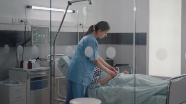 Hasta yatakta solunum rahatsızlığı çekerken sağlık hemşiresi kalp atışlarını izliyor.