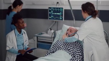 Afro-Amerikalı doktor, hasta adamla semptom hastalığını tartışıyor.