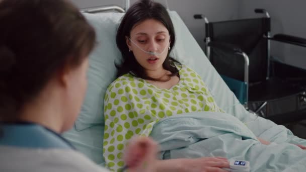 Sjuk patient liggande i sängen talar med läkare förklara sjukdomssymptom — Stockvideo