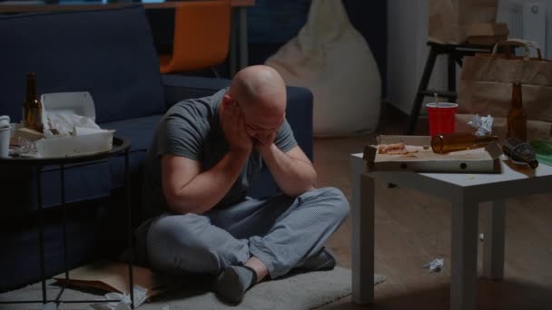 Zdesperowany, beznadziejny człowiek, siedzący samotnie na podłodze, kołyszący się myślami samobójczymi. — Wideo stockowe