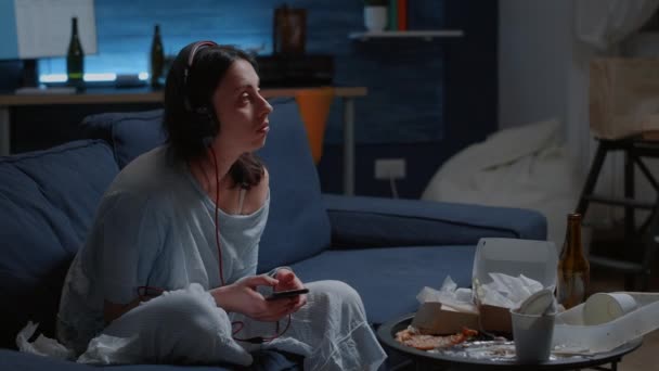 Traumatisasi, frustrasi, stres, depresi wanita mendengarkan musik di telepon — Stok Video