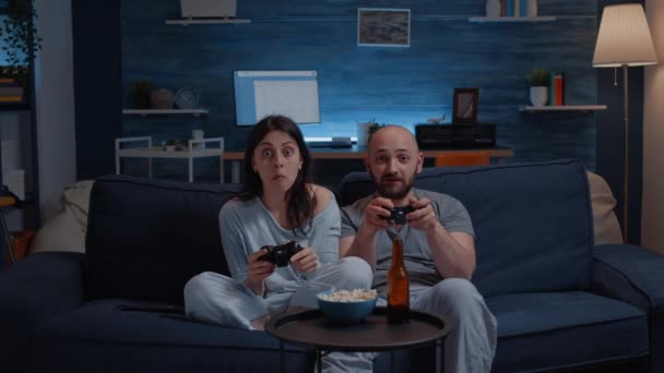 Решительная восторженная пара, победившая в видеоиграх — стоковое видео