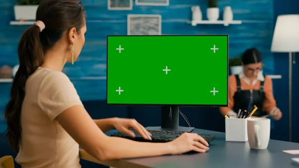 Donna che guarda il computer con schermo verde modellare display a chiave cromatica — Foto Stock