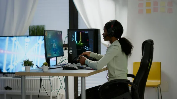 Czarna kobieta gracz wygrywa gry wideo za pomocą profesjonalnego kontrolera bezprzewodowego — Zdjęcie stockowe