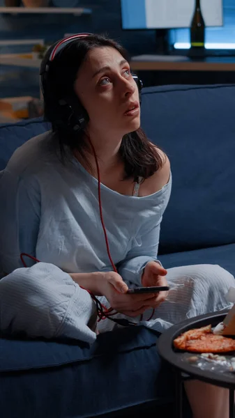 Sad thoughtful anxious woman listening music using smartphone