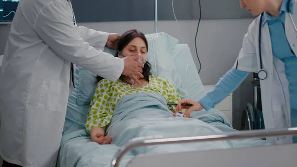Medizinisches Team überprüft Herzschlag einer kranken Frau bei Atemwegserkrankungen — Stockfoto