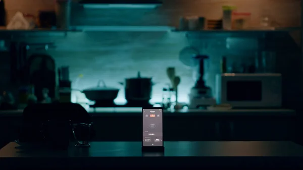 Téléphone avec logiciel intelligent placé sur la table dans la cuisine avec personne dans — Photo
