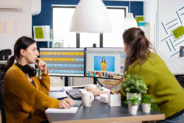 Yaratıcı stüdyoda çalışan kendine güvenen kadın fotoğraf editörleri.