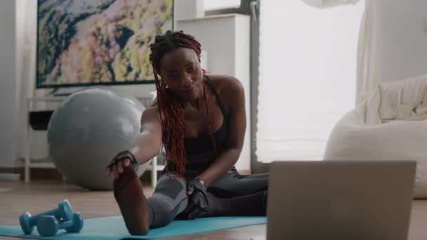 Жінка з чорною шкірою робить тренування у вітальні розтягування вправи — стокове відео