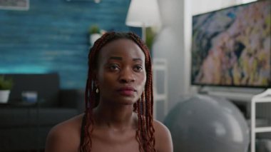 Nilüfer pozisyonunda meditasyon yapan, yoga minderinde oturan atletli kadının yakın çekimi.