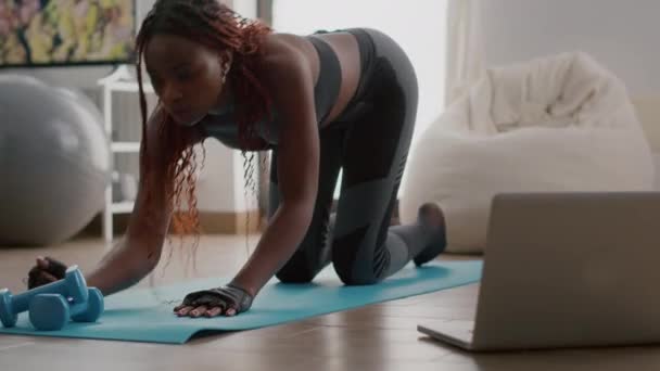 Afro-Amerikaanse vrouw met sportkleding stretching yoga oefeningen op fitness kaart — Stockvideo