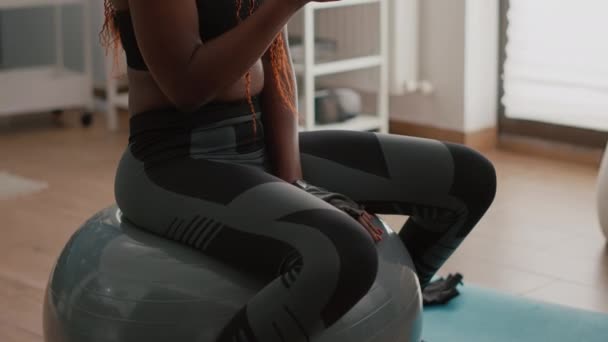 Fit black woman wearing sportswear sitting on yoga swiss ball — Stock Video