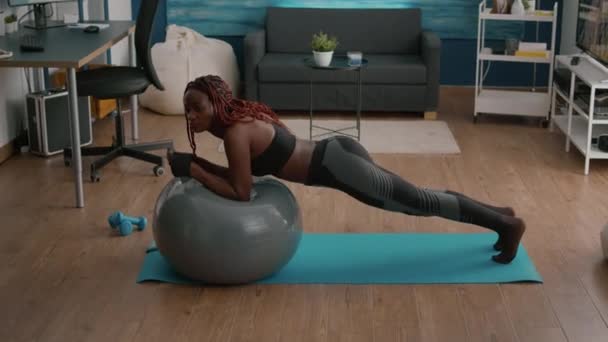 Atletische fitte vrouw die buikspier werkt terwijl zij op yoga Zwitserse bal zit — Stockvideo