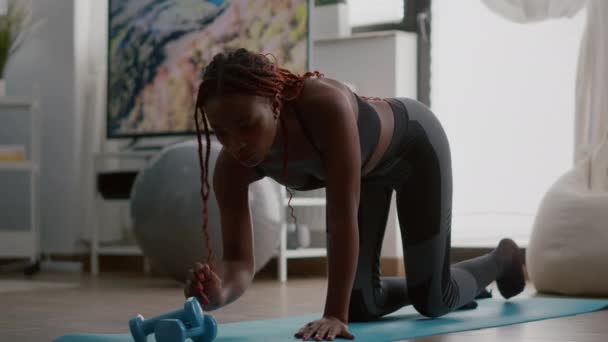 Idrottare afrikan i sportkläder gör fitness övningar sätta kronometer på telefonen — Stockvideo