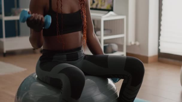 Тонкая женщина с черной кожей делает упражнения с гантелями — стоковое видео