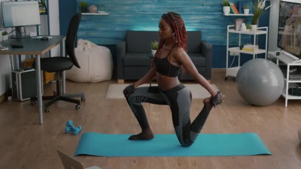 Fitnessvrouw met zwarte huid die fitnesstraining in de woonkamer beoefent — Stockvideo