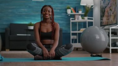 Siyah sporcunun portresi Lotus pozisyonunda sabah sporunun keyfini çıkarıyor.