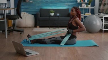 Spor giyim sektöründe aerobik sporu izleyen siyah bir kadın.