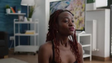 Esnek tenli, spor giyinen, evde yoga yapan esnek bir kadın.