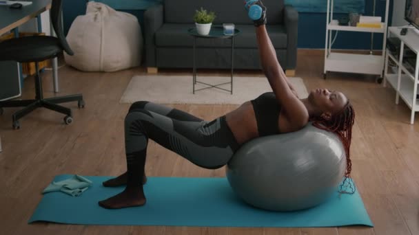 Тонкая атлетичная женщина с темной кожей, работающая мышца тела, делает утренние упражнения — стоковое видео