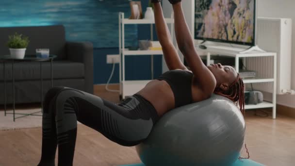Schlanke Frau mit schwarzer Haut trainiert Körpermuskulatur beim morgendlichen Training — Stockvideo