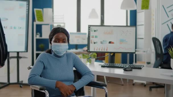 Portret van een Afrikaanse vrouw met beschermend gezichtsmasker kijkend naar de camera — Stockvideo