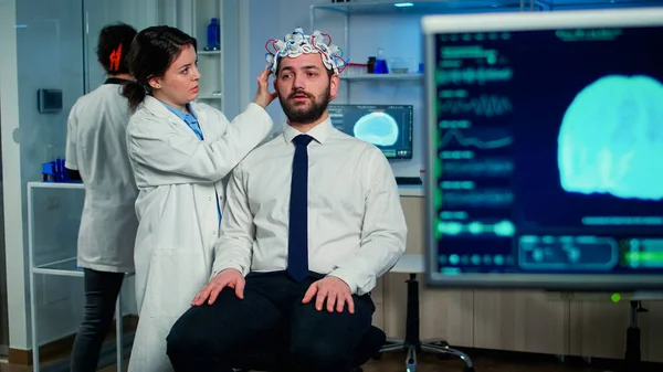 Un chercheur médical met un casque performant à balayage d'ondes cérébrales — Photo
