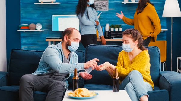 혼합 인종 친구들 과 의료용 마스크가 혼합 된 사람들 이손을 소독 한다 — 스톡 사진