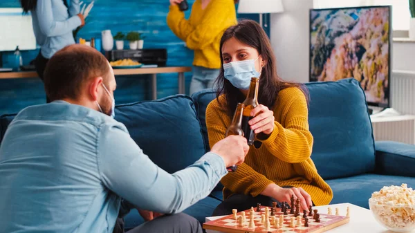 Přátelé baví hrát šachy v obývacím pokoji během globální pandemie — Stock fotografie