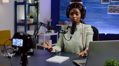 Afrikalı blogcu kadın izleyicilerle konuşuyor. Video kameraya bakıyor.