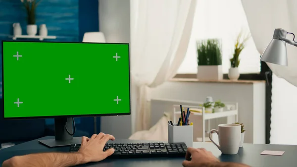 Pov de mains de l'homme assis sur le bureau en utilisant l'ordinateur avec la clé chromatique écran vert maquette — Photo