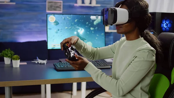Black woman player with vr goggles raising hands holding joystick — Stock Photo, Image