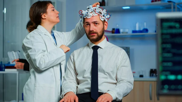 뇌파 스캐닝 헤드셋을 가지고 뇌 연구 실험실에 앉아 있는 환자 — 스톡 사진