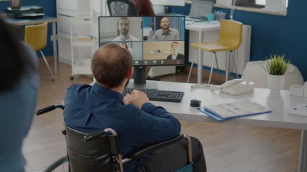 Behinderter gelähmter Manager spricht mit Team auf Videoleinwand — Stockvideo