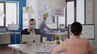 Koruma maskeli serbest çalışan yeni strateji için telefonda konuşuyor.