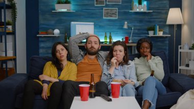 Televizyonda korku filmi izleyen bir grup melez insan.
