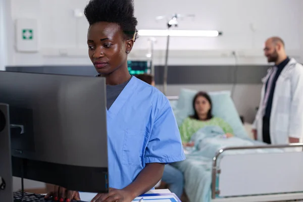 Noir médical asisstant typage maladie traitement sur ordinateur — Photo