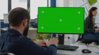 Felç olmuş sakat iş adamı yeşil ekranlı bilgisayar kullanarak koltukta oturuyor.