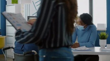 Engelli ofis müdürü siyahi meslektaşına mali açılışı yapıyor.