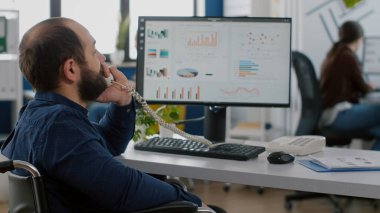 Geçersiz engelli proje yöneticisi iş arkadaşıyla telefonda konuşuyor