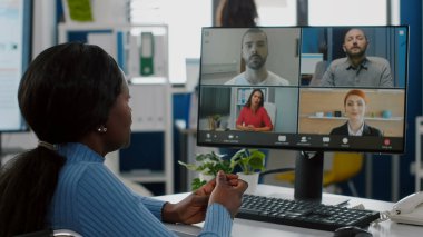 Tekerlekli sandalyedeki hareketsiz siyah proje yöneticisi video çağrısında konuşuyor