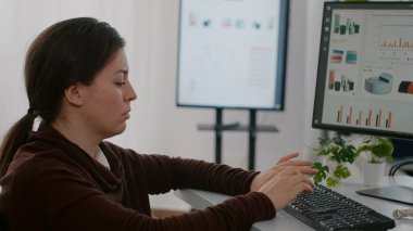 Engelli işçi bilgisayardaki mali istatistikleri analiz ediyor.