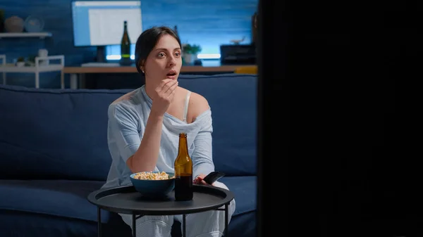 Emocional joven mujer comiendo palomitas de maíz mientras ve repugnante película de televisión — Foto de Stock