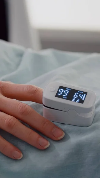 Közelkép a kórházi nő ujj pulzusmérő mutatja pulzus — Stock Fotó