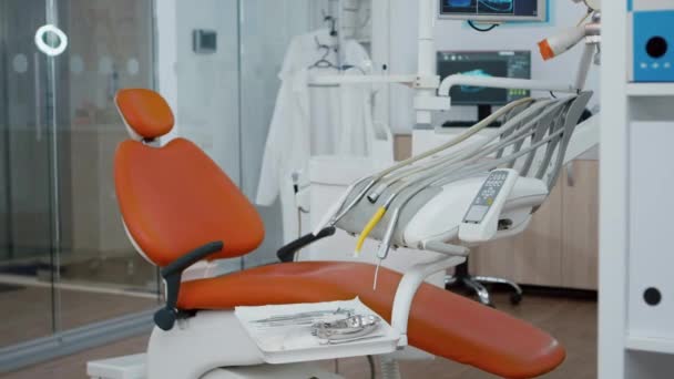 Revelando tiro da cadeira odontológica ortodontista com ninguém dentro, preparado para a saúde dental dos dentes. — Vídeo de Stock