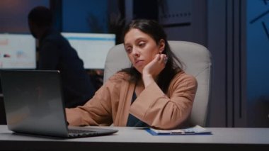 Yorgun işkolik müdürün portresi dizüstü bilgisayar kullanarak ekonomik istatistikleri kontrol ediyor