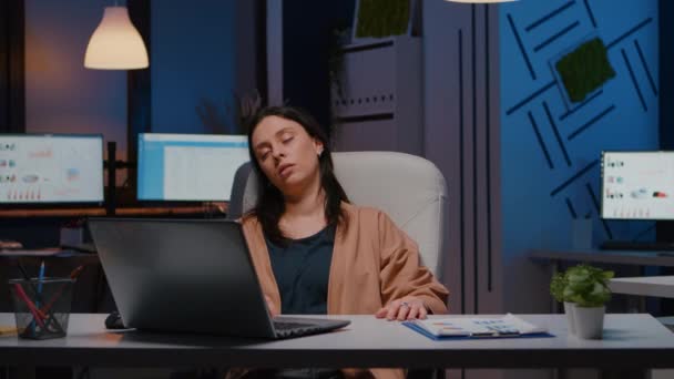 Mujer empresaria agotada durmiendo frente a la computadora portátil mientras analiza las estadísticas financieras — Vídeo de stock