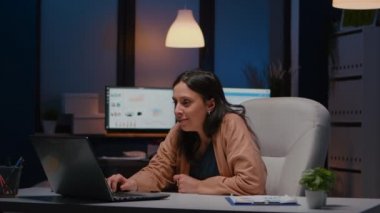 Dizüstü bilgisayara bakarken gülümseyen neşeli iş kadını